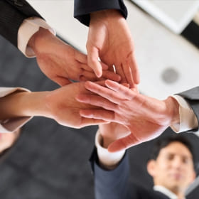 ３つの事業が手を合わせている様子